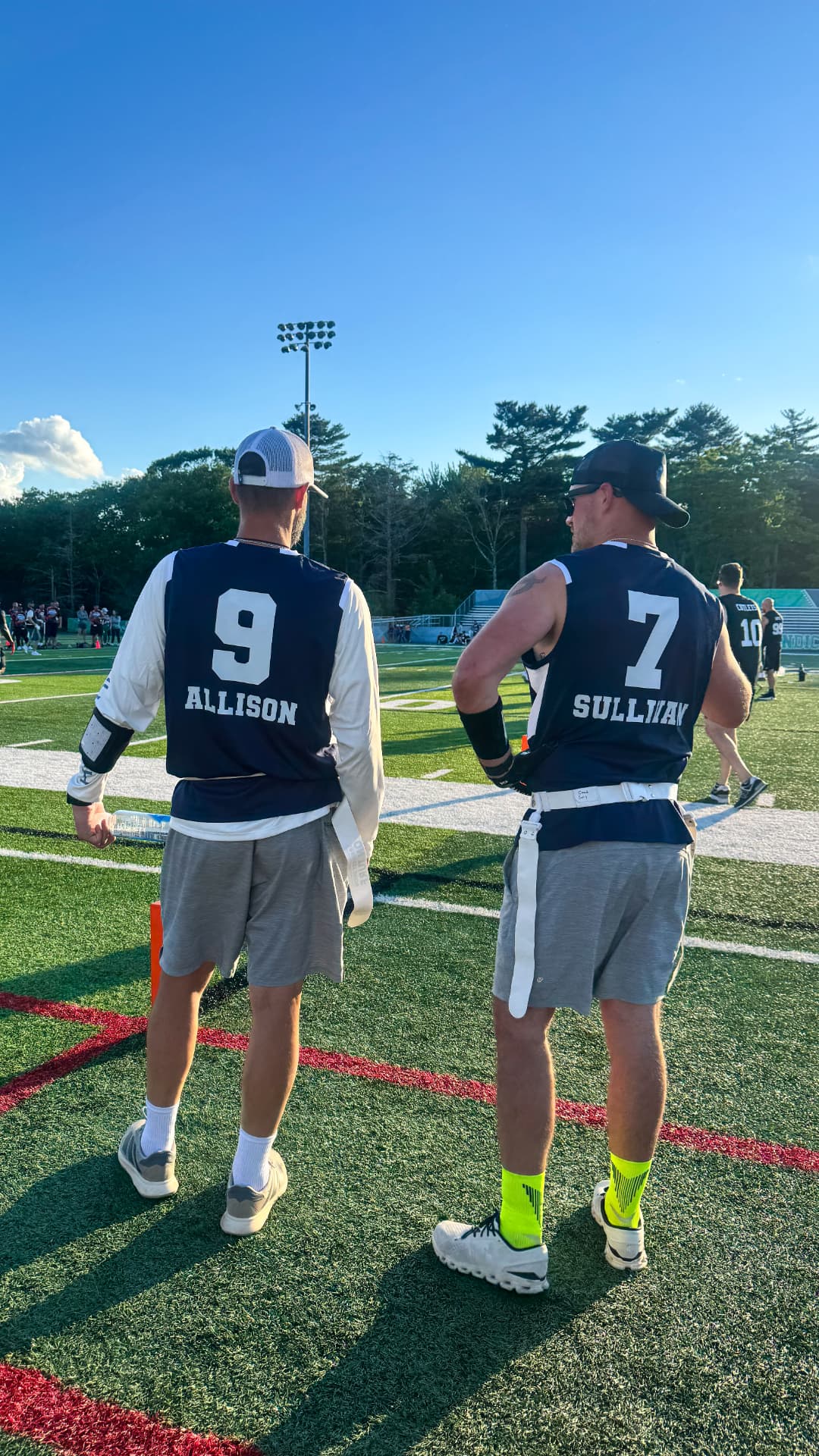 Flag football coaches talking through calls on the sideline during a game